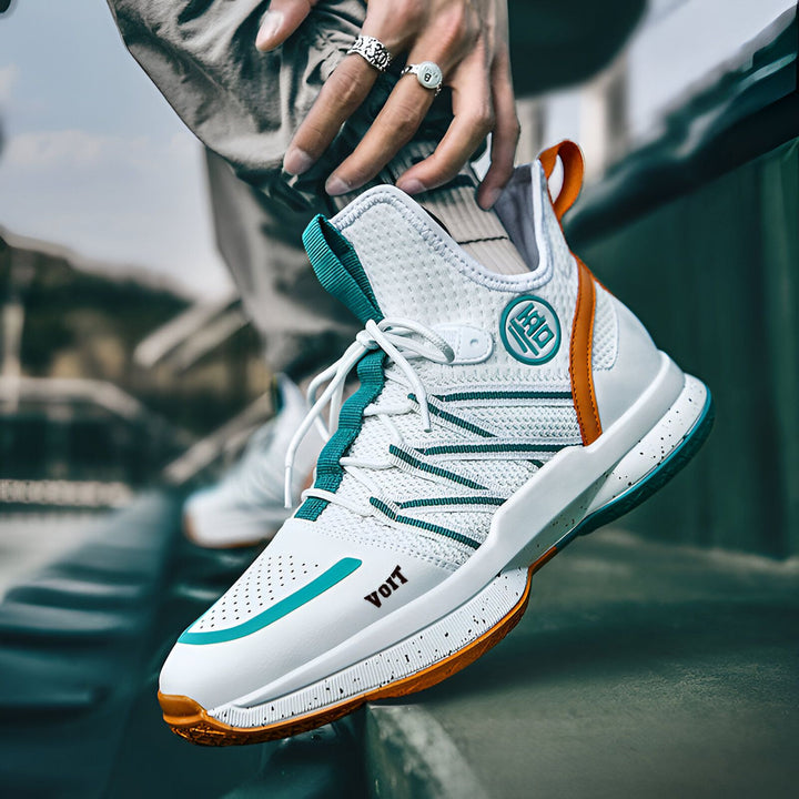 Une personne porte une paire de chaussures de basketball blanches, bleues et orange. Les chaussures sont de marque "VOIT".,CH-6674834599,CH-0154801445,CH-6761175593,CH-0860846431,CH-8472135896,CH-0534469272
