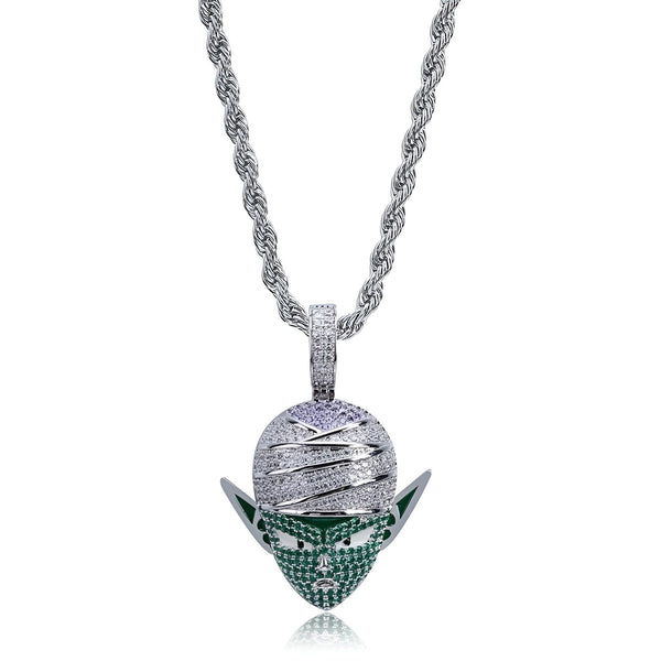 Le pendentif représente le personnage Piccolo de la série Dragon Ball Z. Il est de couleur verte et porte une sorte de turban sur la tête. Le pendentif est en métal et est recouvert de zircons. Il est accroché à une chaîne en argent.,CO-5123169970,CO-294831724X