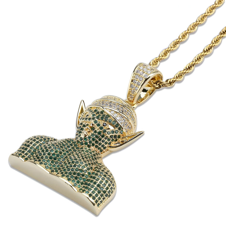 Le pendentif représente le personnage Piccolo de la série Dragon Ball Z. Il est de couleur verte et est serti de pierres précieuses. Il est suspendu à une chaîne en or.