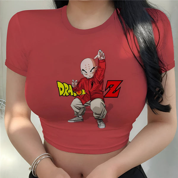 Une jeune femme porte un t-shirt rouge avec un personnage de Dragon Ball Z dessus. Le personnage est Krilin, et il est représenté en train de se battre. Le t-shirt est court et露出了腹部。 La femme a les cheveux longs et noirs.,CR-1400659442,CR-8093223770,CR-7043688361,CR-6313022998,CR-689181975X,CR-0788430785,CR-1494452219