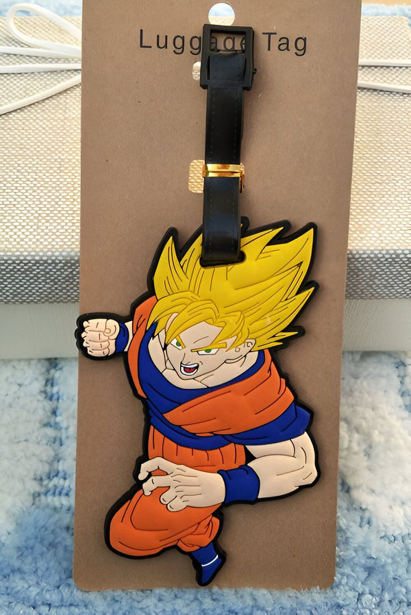 Un porte-étiquette de bagage en caoutchouc à l'effigie de Son Goku, un personnage de la série animée Dragon Ball Z. Il est vêtu de son costume orange et bleu et est en position de combat.,É-6827107574