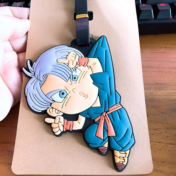 Un porte-clés en caoutchouc à l'effigie de Trunks, un personnage de Dragon Ball Z. Il est vêtu de son costume bleu et blanc et a les cheveux bleus. Il est en train de se pointer du doigt.,É-0412303051