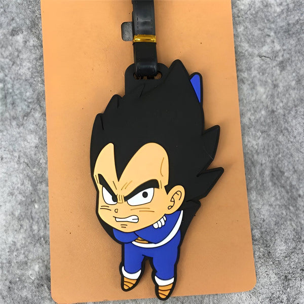 Un porte-clés en caoutchouc à l'effigie de Vegeta, un personnage de la série animée Dragon Ball Z. Vegeta est représenté avec ses cheveux noirs hérissés, son armure bleue et son regard déterminé. Le porte-clés est fixé à un mousqueton en métal.,É-3605878393