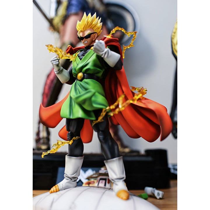Une figurine de Gohan, un personnage de Dragon Ball Z, est debout sur un socle blanc. Il porte une cape rouge et un costume vert. Il a les cheveux jaunes et les yeux bleus. Il est en position de combat.,FI-1029693552