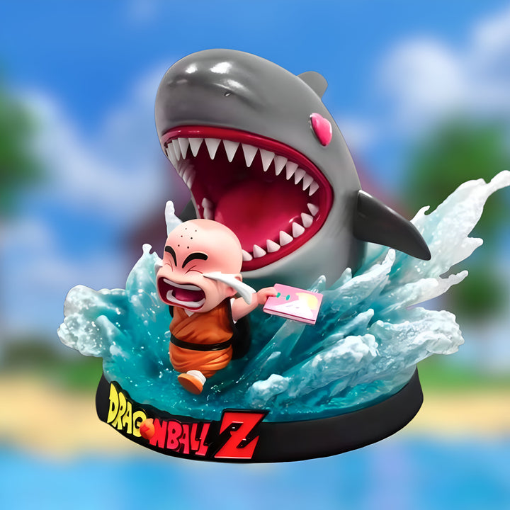 Une figurine de Krilin chevauchant un requin géant. Krilin est un personnage de la série Dragon Ball Z. Il est le meilleur ami de Son Goku. Krilin est un humain et il est très intelligent. Il est aussi très fort et il sait se battre. Le requin est un animal marin qui est très dangereux. Il a des dents très pointues et il peut manger les gens. Krilin est en danger mais il ne semble pas avoir peur. Il est prêt à se battre contre le requin.,FI-090087757X