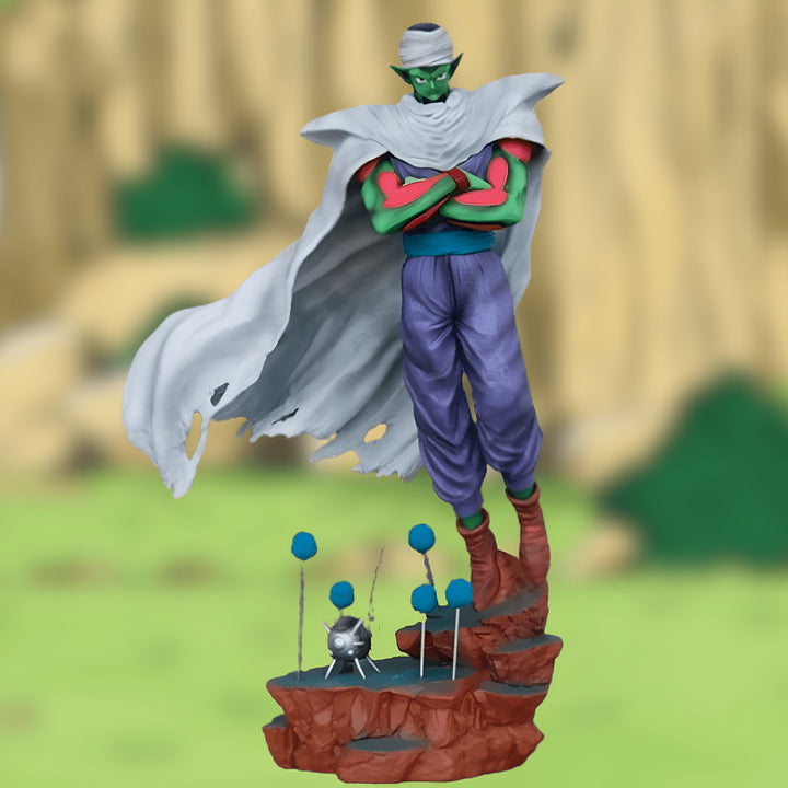 Une figurine de Piccolo, un personnage de Dragon Ball Z. Il est vêtu de son costume vert et blanc et porte une cape blanche. Il est debout sur un socle rocheux et est entouré de boules bleues.,FI-3293092977