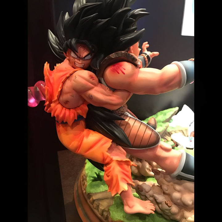 Une figurine de Goku et Raditz en train de se battre. Goku est un Saiyan avec des cheveux noirs et des yeux bleus, et il porte une combinaison orange et bleue. Raditz est un Saiyan avec des cheveux noirs et des yeux bleus, et il porte une armure noire et violette.,FI-6279066541
