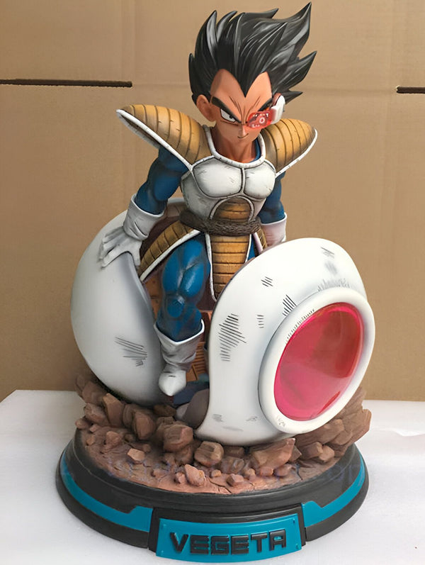 Une figurine de Vegeta, un personnage de Dragon Ball Z, debout sur un socle en forme de capsule spatiale. Vegeta est vêtu de son armure de combat et a les cheveux noirs hérissés. Il est en position de combat, le poing droit levé et le regard déterminé.,FI-112558145X