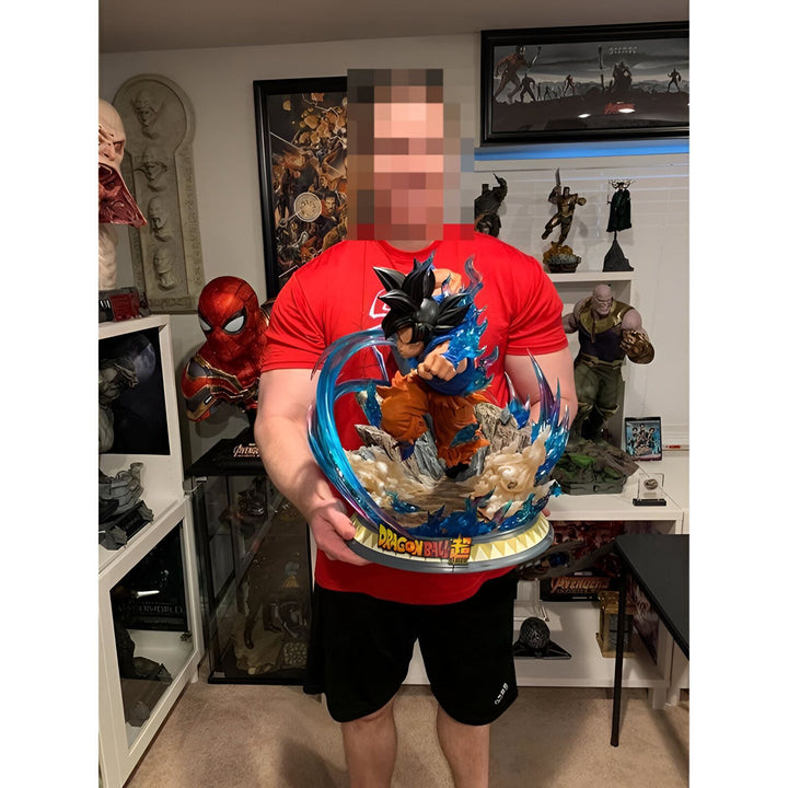 Une image d'un homme tenant une figurine de Son Goku, un personnage de Dragon Ball Z. La figurine est en résine et mesure environ 30 cm de haut. Elle est très détaillée et représente Son Goku en train de se battre. L'homme porte un t-shirt rouge et un short noir. Il est souriant et semble heureux de tenir la figurine. En arrière-plan, on peut apercevoir une étagère avec d'autres figurines de Dragon Ball Z.,FI-5169885547