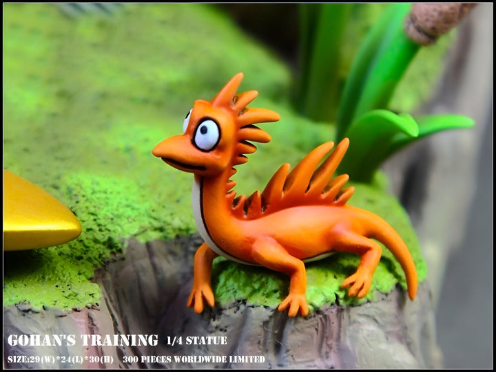 Une figurine orange de Gohan en position d'entraînement, accroupi sur un rocher. Il porte une carapace orange avec des pointes sur le dos et une crête sur la tête. Il a de grands yeux bleus et une bouche ouverte. La figurine est entourée de plantes vertes et de rochers.,FI-805340927X