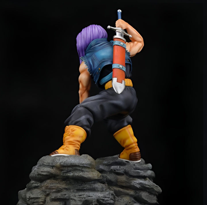 Une figurine de Trunks du futur, un personnage de Dragon Ball Z. Il est vêtu d'un gilet bleu, d'un pantalon noir et de bottes jaunes. Il porte une épée dans le dos. La figurine est debout sur un rocher.,FI-7389337834