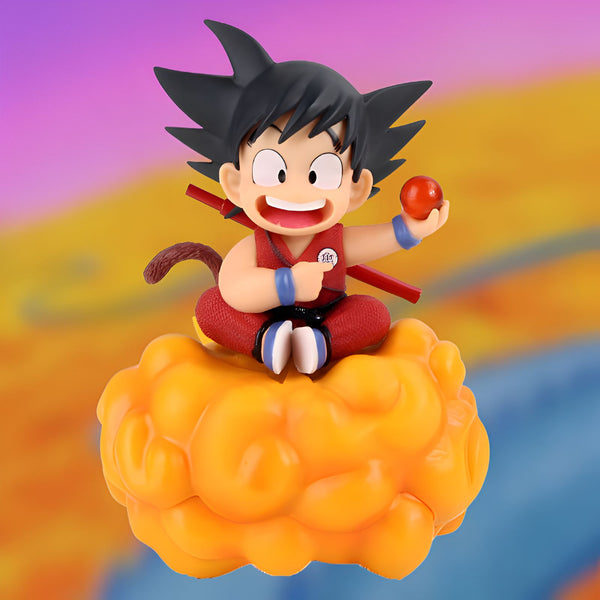 Une figurine de Son Goku, un personnage de Dragon Ball Z, assis sur un nuage magique et souriant. Il porte une combinaison orange et bleue et tient une boule de cristal à la main.,FI-9809827229