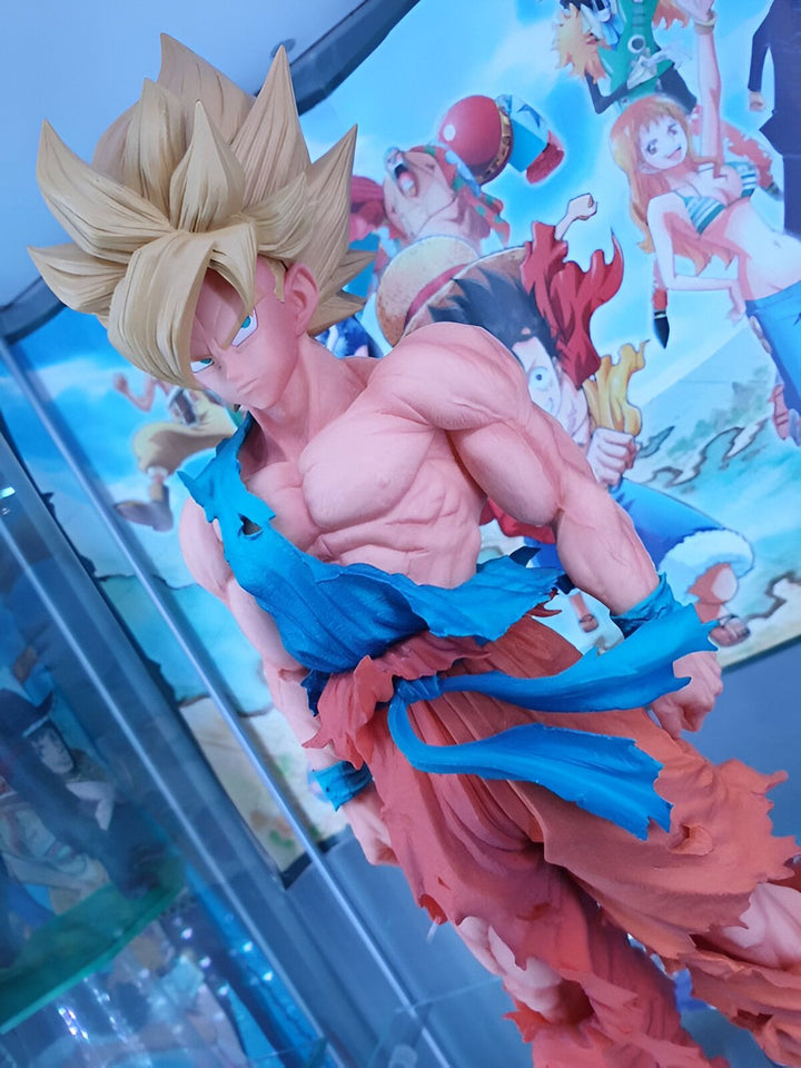 Une figurine de Son Goku, un personnage de la série animée Dragon Ball Z. Il est représenté avec ses cheveux blonds hérissés, sa peau dorée et ses muscles saillants. Il porte un pantalon orange déchiré et une ceinture bleue. Il est en position de combat, le poing droit levé et le regard déterminé.,FI-4930058376