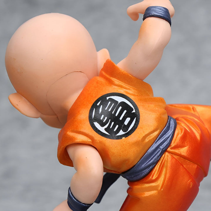 Une figurine de Krilin, un personnage de Dragon Ball Z, en train de se battre. Il est vêtu d'un kimono orange et blanc et a les cheveux rasés.,FI-9230761451