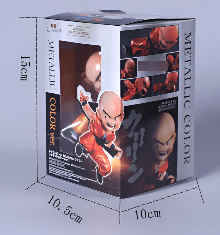 Une figurine de Krilin dans sa version couleur métallique. La figurine est dans une boîte transparente avec un socle orange. La boîte est de 15 cm de hauteur, 10,5 cm de largeur et 10 cm de profondeur.,FI-9230761451