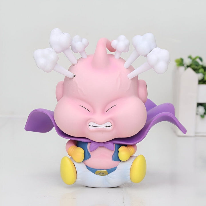Une figurine de Majin Buu, un personnage de Dragon Ball Z. Il est rose, avec une tête ronde et de grands yeux. Il porte une cape violette et une couche. Il est assis sur le sol et a l'air en colère.,FI-8463921574