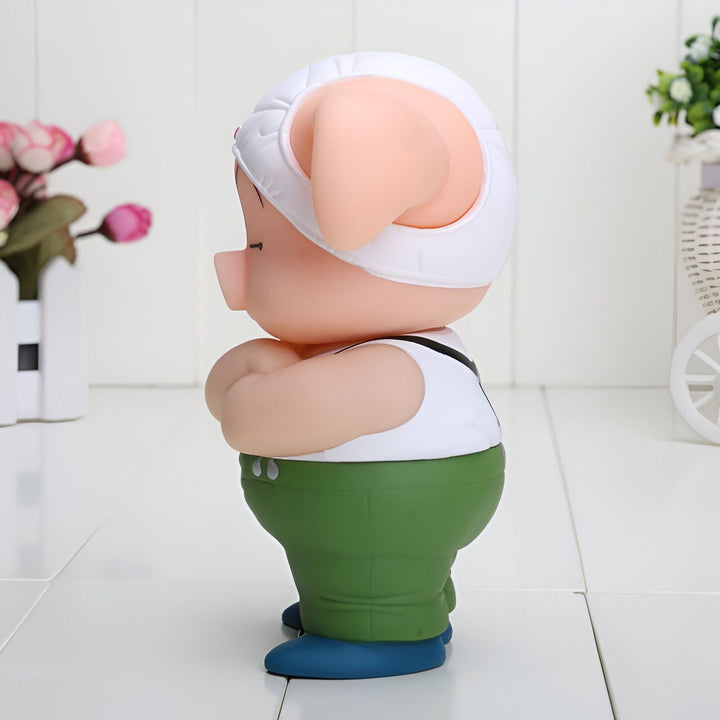 Une image d'un cochon en plastique rose avec un chapeau blanc et un pantalon vert. Il est debout sur une surface blanche.,FI-9862983256