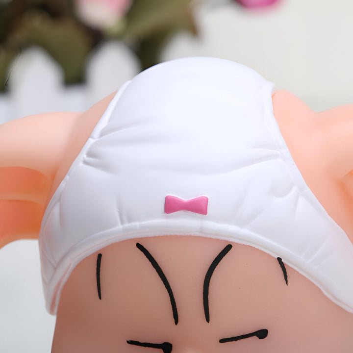 L'image représente le haut d'un personnage de dessin animé qui porte une couche blanche avec un nœud rose.,FI-9862983256