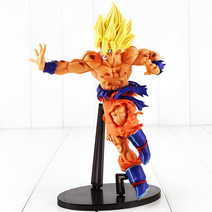 Une figurine de Son Goku, un personnage de la série animée Dragon Ball Z. Il est représenté en Super Saiyan, avec les cheveux jaunes et les yeux bleus. Il porte une combinaison orange et bleue déchirée et est en position de combat.,FI-4265488455