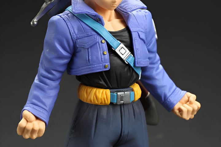 Une figurine de Trunks, un personnage de Dragon Ball Z. Il porte une veste bleue, un pantalon bleu et une ceinture jaune. Il a les cheveux bleus et les yeux bleus. Il est en position de combat.,FI-772317795X