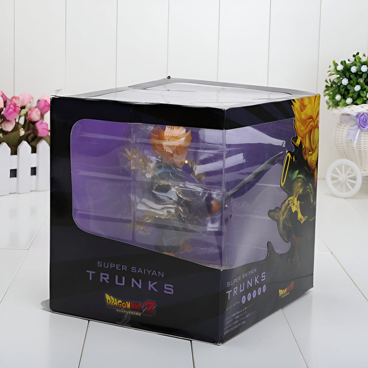Une figurine de Trunks, un personnage du manga Dragon Ball Z. Il est représenté dans sa forme Super Saiyan, avec les cheveux jaunes et les yeux bleus. Il porte une combinaison bleue et jaune, et tient une épée dans sa main droite. La figurine est dans une boîte transparente, avec un socle noir.,FI-4607500992