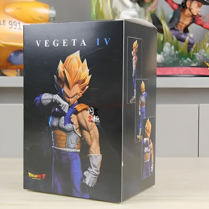 Une figurine de Vegeta, un personnage de la série Dragon Ball Z. Il est représenté dans sa tenue de combat bleue et jaune, avec ses cheveux blonds hérissés. La figurine est posée sur un socle noir et est entourée d'un packaging en carton noir avec une illustration de Vegeta en fond.,FI-7340717927
