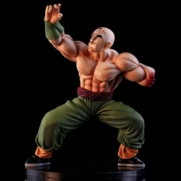 Une figurine de Tenshinhan, un personnage de Dragon Ball Z. Il est représenté en position de combat, avec un bras tendu vers l'avant et l'autre replié près de son corps. Il porte un pantalon vert et une chemise orange, et a les cheveux noirs et les yeux bleus. La figurine est posée sur un socle noir.,FI-9826513059