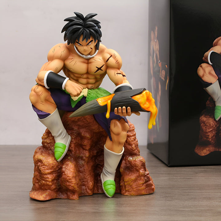 Une figurine de Broly, un personnage de Dragon Ball Z, est assise sur un rocher. Il a les cheveux noirs et les yeux bleus, et il est vêtu d'un pantalon violet et d'une ceinture verte. Il tient dans sa main droite une corne d'où coule un liquide jaune.,FI-3271800022