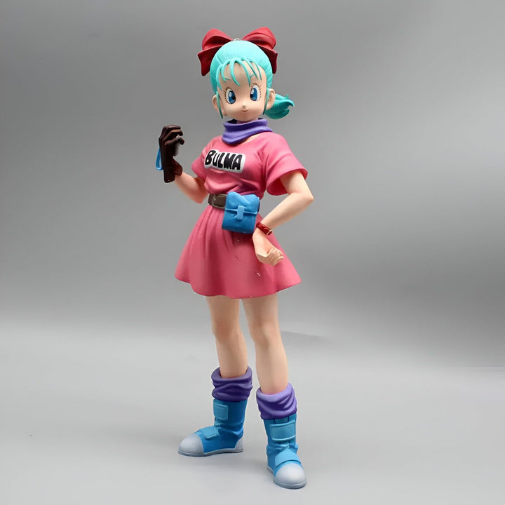 Une figurine de Bulma, un personnage de Dragon Ball Z. Elle porte une robe rose, un nœud rouge dans les cheveux et des bottes bleues. Elle est souriante et a l'air confiante.,FI-1374037761