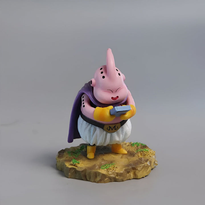 Une figurine de Majin Buu, un personnage de Dragon Ball Z. Il est rose, avec un grand sourire et porte une cape violette. Il est debout sur un socle marron.,FI-7068678459