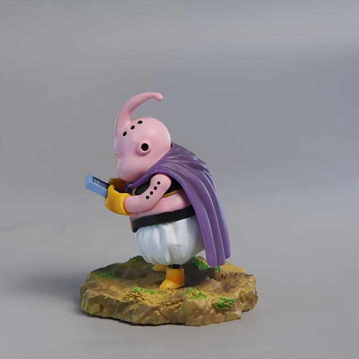 Une figurine de Majin Buu, un personnage de Dragon Ball Z. Il est rose, avec un nez et des joues bleus, et porte une cape violette. Il est en train de lire un livre.,FI-7068678459
