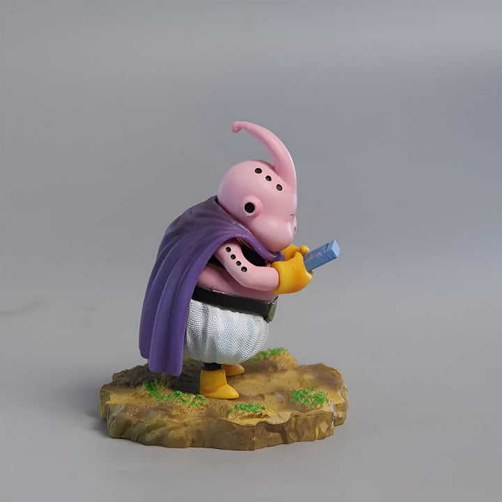 Une figurine de Majin Buu, un personnage de Dragon Ball Z. Il est rose, avec un pantalon blanc et une cape violette. Il est en train de lire un livre.,FI-7068678459