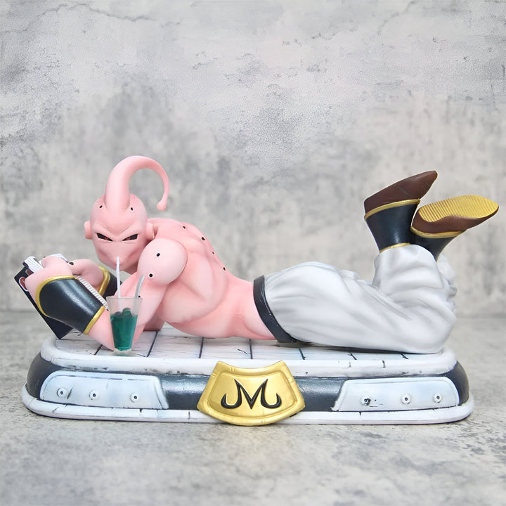 Une figurine de Majin Buu, un personnage de Dragon Ball Z, est allongée sur le sol et lit un magazine. Il porte un pantalon blanc et des bottes marron et tient un verre à la main.,FI-6216665758