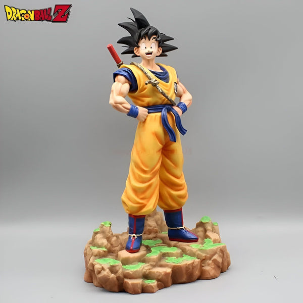 Une figurine de Son Goku, un personnage de Dragon Ball Z. Il est vêtu de son costume orange et bleu et porte une épée à la ceinture. Il se tient debout sur un rocher et sourit.,FI-6899787709