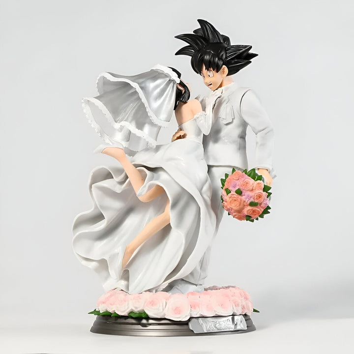 Une figurine de mariage de Son Goku et de Chichi, deux personnages de la série animée Dragon Ball Z. Son Goku porte un costume noir et une cravate blanche, et Chichi porte une robe de mariée blanche. Ils sont tous les deux souriants et heureux.,FI-3641427797