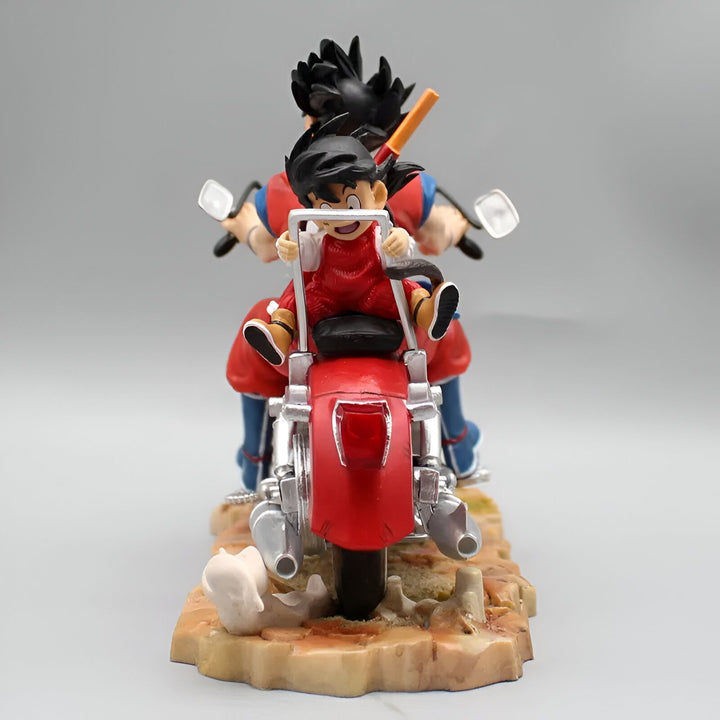 Une figurine de Goku et Gohan sur une moto. Goku est en train de conduire la moto et Gohan est assis derrière lui. La moto est rouge et a un siège noir. Goku porte une combinaison bleue et Gohan porte une combinaison orange.,FI-3986581812