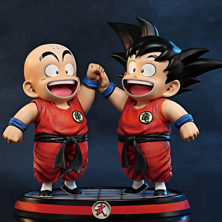 Une image de deux figurines de Son Goku et Krilin, personnages du dessin animé Dragon Ball Z. Les deux figurines sont en train de se tenir la main et sont placées sur un socle rouge et noir.,FI-2403265217