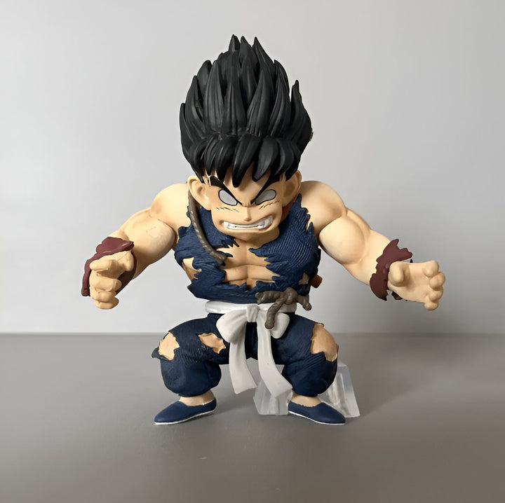 Une figurine de Son Goku enfant, personnage de la série Dragon Ball Z. Il est représenté avec ses vêtements déchirés et ses cheveux noirs hérissés. Il est en position de combat, les poings serrés et le regard déterminé.,FI-711612876X