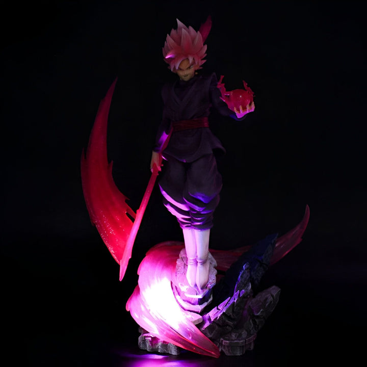 Une figurine de Son Goku, un personnage de Dragon Ball Z, dans sa forme Black. Il est vêtu d'une combinaison noire et rose, et tient une faux dans sa main droite. La figurine est éclairée par une lumière violette.,FI-4899512767