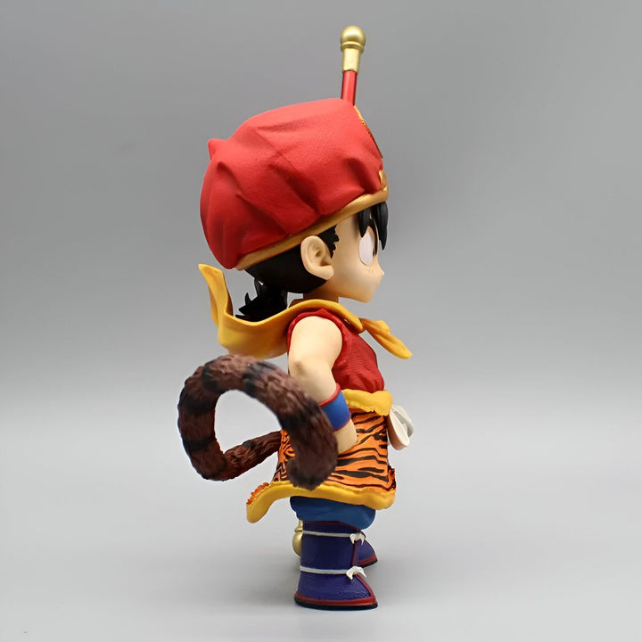 Une figurine de Son Gokû enfant portant une tenue traditionnelle chinoise avec un pantalon orange et un gilet jaune. Il a une queue de singe et un bâton magique à la main.,FI-4401880579