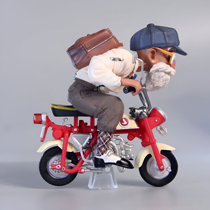 Une figurine de vieil homme avec une casquette bleue, des lunettes et une barbe blanche est assise sur une moto rouge et blanche. Il porte une chemise blanche, un pantalon marron et des chaussures noires. Il a un sac marron sur le dos. La moto est posée sur un support transparent.,FI-9738210933