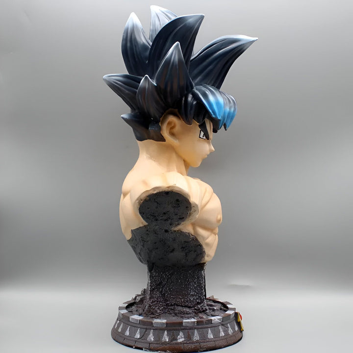 Buste de Son Goku, un personnage de la série animée Dragon Ball Z. Il est représenté avec ses cheveux noirs et bleus hérissés, et son regard déterminé. Il porte une cuirasse bleue et orange. Le buste est posé sur un socle noir.,FI-7051017179