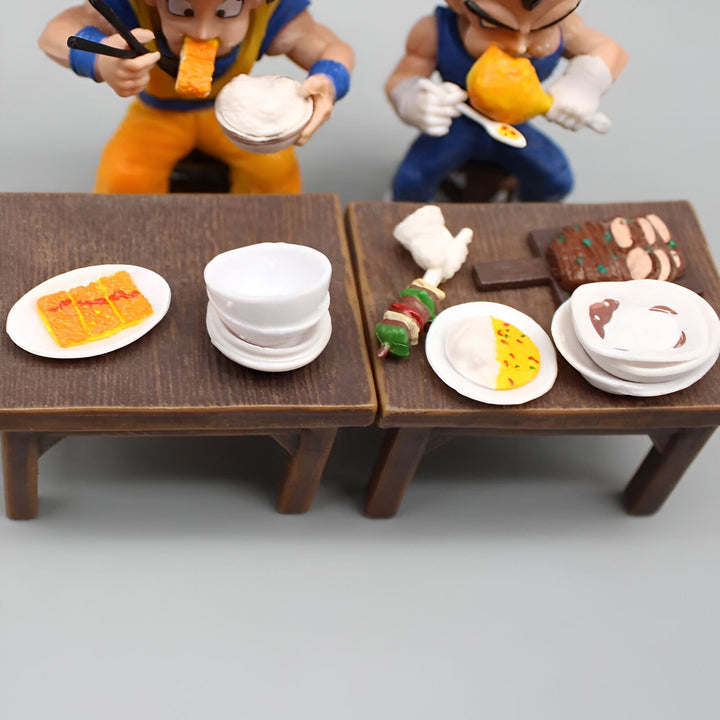 Deux figurines de Dragon Ball Z, Goku et Vegeta, sont assises à une table et mangent. Il y a deux tables avec de la nourriture dessus. Sur la table de gauche, il y a une assiette de riz, une assiette de curry et une assiette de nouilles. Sur la table de droite, il y a une assiette de viande, une assiette de légumes et une assiette de poisson.,FI-6433225225