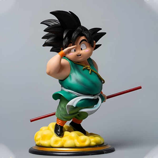Une figurine de Son Goku enfant, un personnage de Dragon Ball. Il est représenté avec ses cheveux noirs hérissés, sa peau claire et ses yeux bleus. Il porte une tenue verte et orange et tient un bâton à la main. Il est debout sur un nuage jaune et blanc.,FI-0030491541