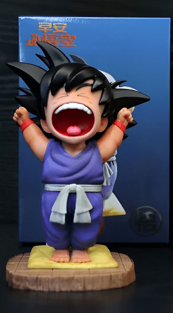 Une figurine de Son Goku, un personnage de la série animée Dragon Ball Z. Il est représenté en train de s'étirer et de bâiller. Il porte un pantalon violet, une ceinture blanche et des bracelets rouges. Il est debout sur un socle en bois.,FI-1713775565