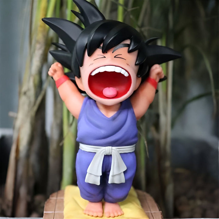 Une figurine de Son Goku, un personnage de Dragon Ball Z, en train de s'étirer et de bâiller. Il est vêtu d'un kimono violet et d'une ceinture blanche.,FI-1713775565