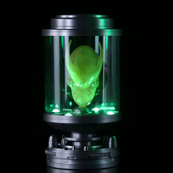 L'image montre un crâne extraterrestre vert dans un tube en verre éclairé par une lumière verte.,FI-9582375493