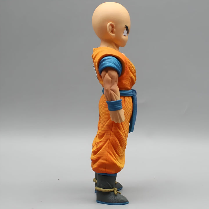 Une figurine de Krilin, un personnage de Dragon Ball Z. Il est chauve, porte une combinaison orange et une ceinture bleue. Il est vu de profil.,FI-6069348427
