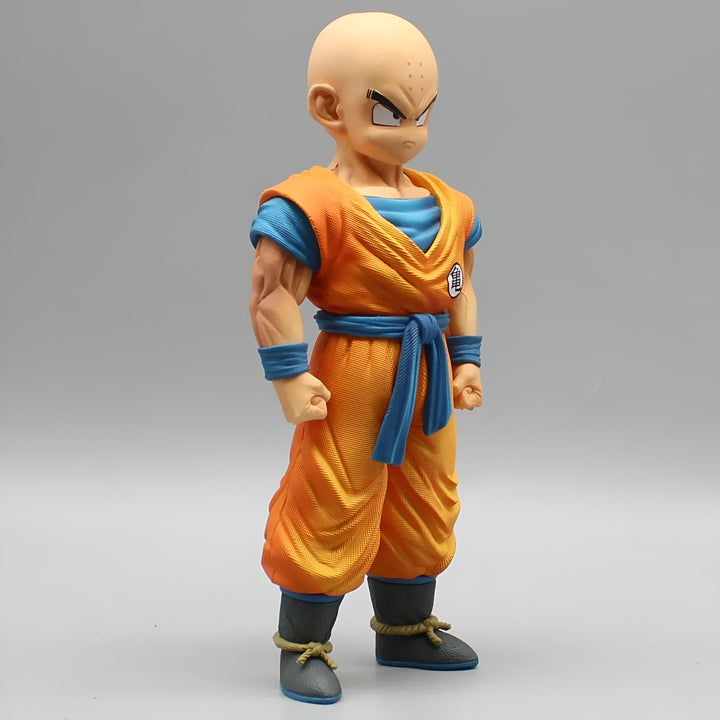 Une figurine de Krilin, un personnage de Dragon Ball Z. Il est chauve, porte une combinaison orange et une ceinture bleue. Il a les poings serrés et est prêt à se battre.,FI-6069348427