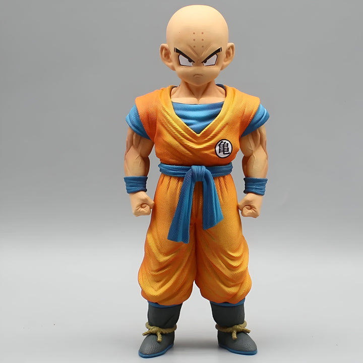 Une figurine de Krilin, un personnage de Dragon Ball Z. Il est chauve, porte une combinaison orange et une ceinture bleue. Il a les poings serrés et est prêt à se battre.,FI-6069348427